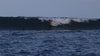 Woman surfing a wave wearing a Tau Swim Bottom and Bindi Top in White